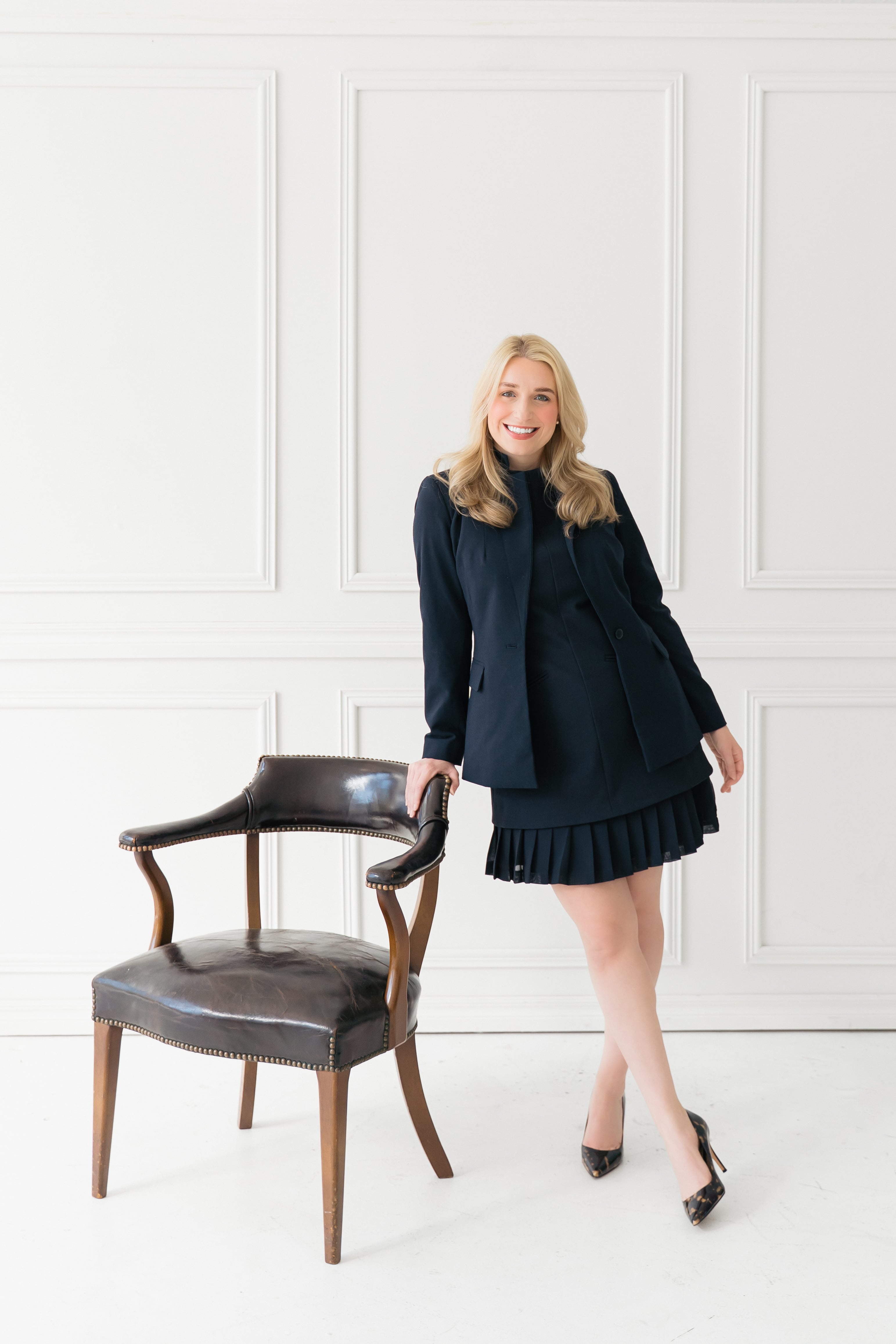 Kaylind Landes standing beside a leather chair in her office